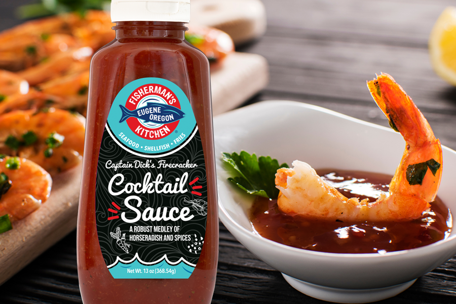 Fisherman's Kitchen bottle of Captain Dick’s Firecracker Cocktail Sauce in foreground with shrimp dipped in the sauce in the background 